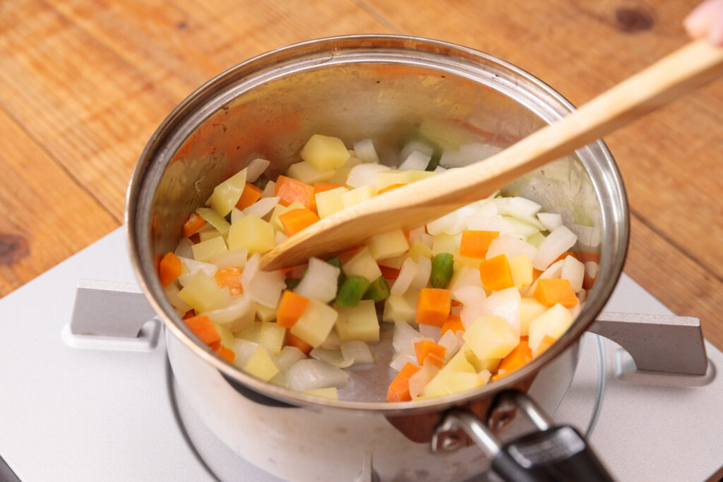 野菜を鍋で炒める